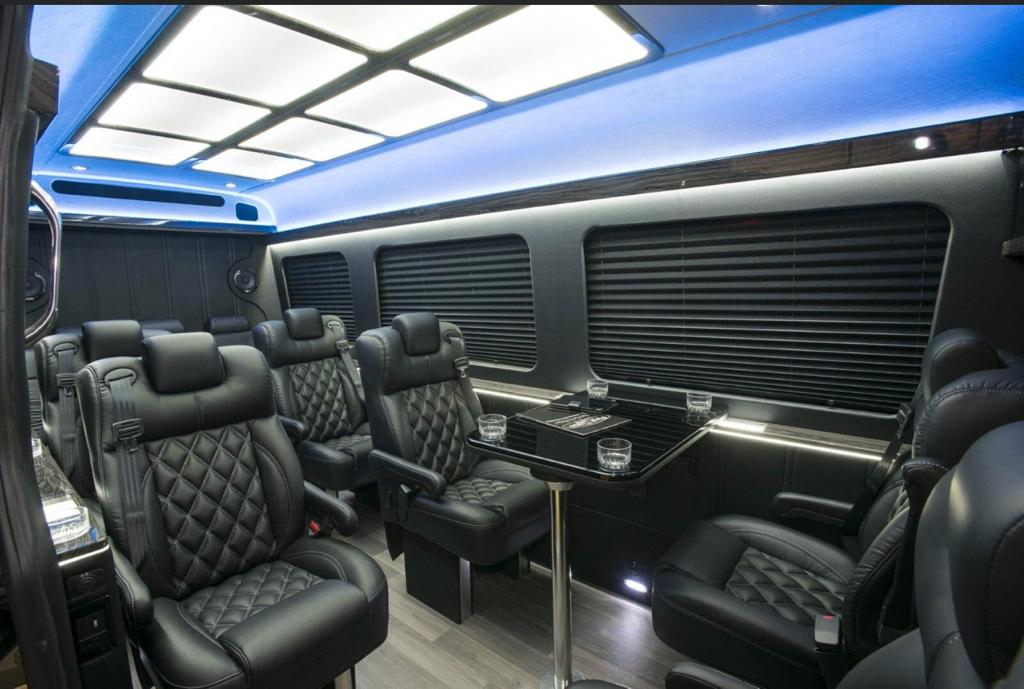 Arvada Limo 2 Close-up of Mercedes sprinter interior with black leather seats and a black dining table.