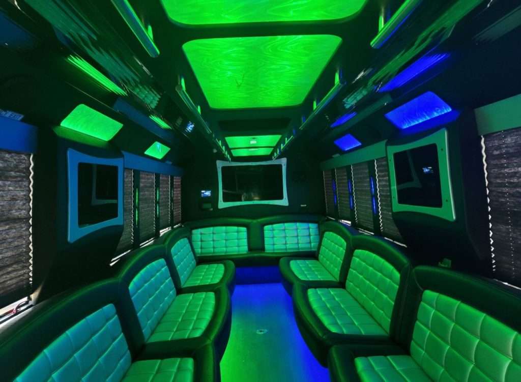 Arvada Limo 3 Interior of a party bus with black and gray leather seats and green lighting.